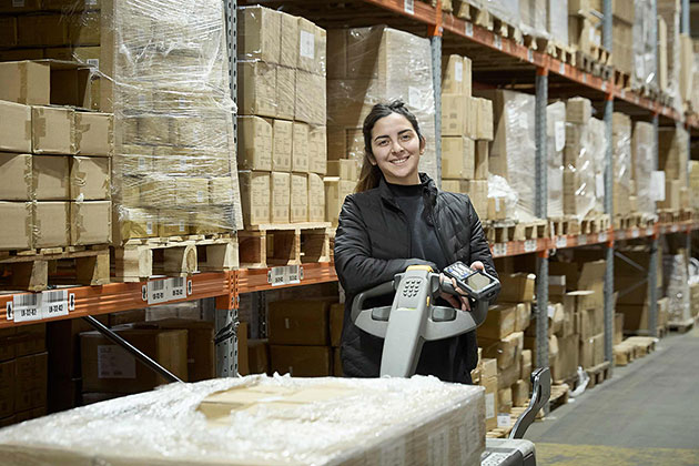 Lagermedarbejder med palleløfter og håndscanner på Ackros moderne lager i Glostrup